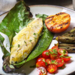 Baked Amberjack White Fish with Thyme Laying On a Green Banana Leaf On A Wood Plate