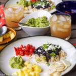 Plate of Black Beans & Rice W/ Tomato Salsa, Guacamole, Pineapple, and sliced turnips.