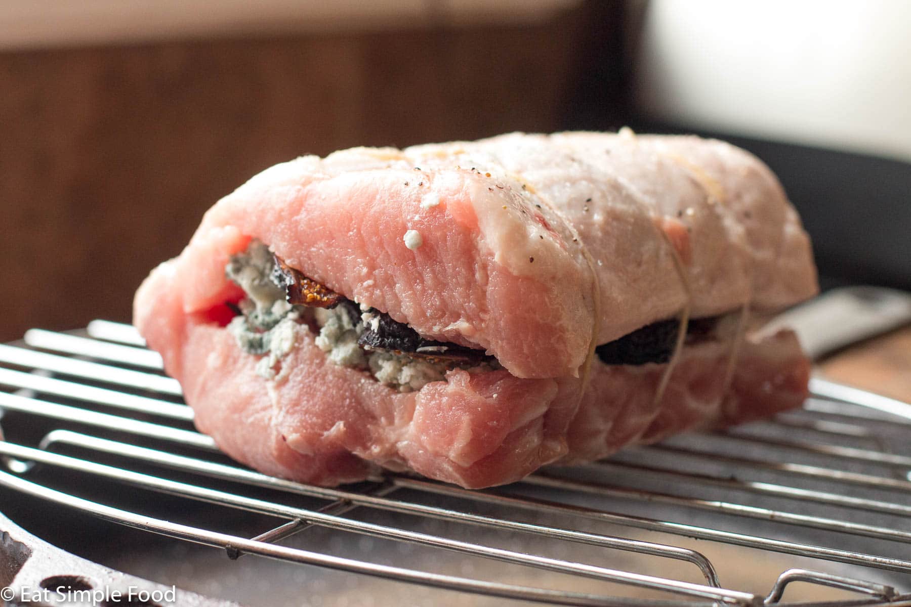 Raw Blue Cheese and Fig Stuffed Pork Tenderloin on an elevated rack.