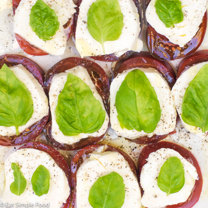 Close up of Red Purple Tomato slices, Mozzarella cheese slices, and basil leaf.