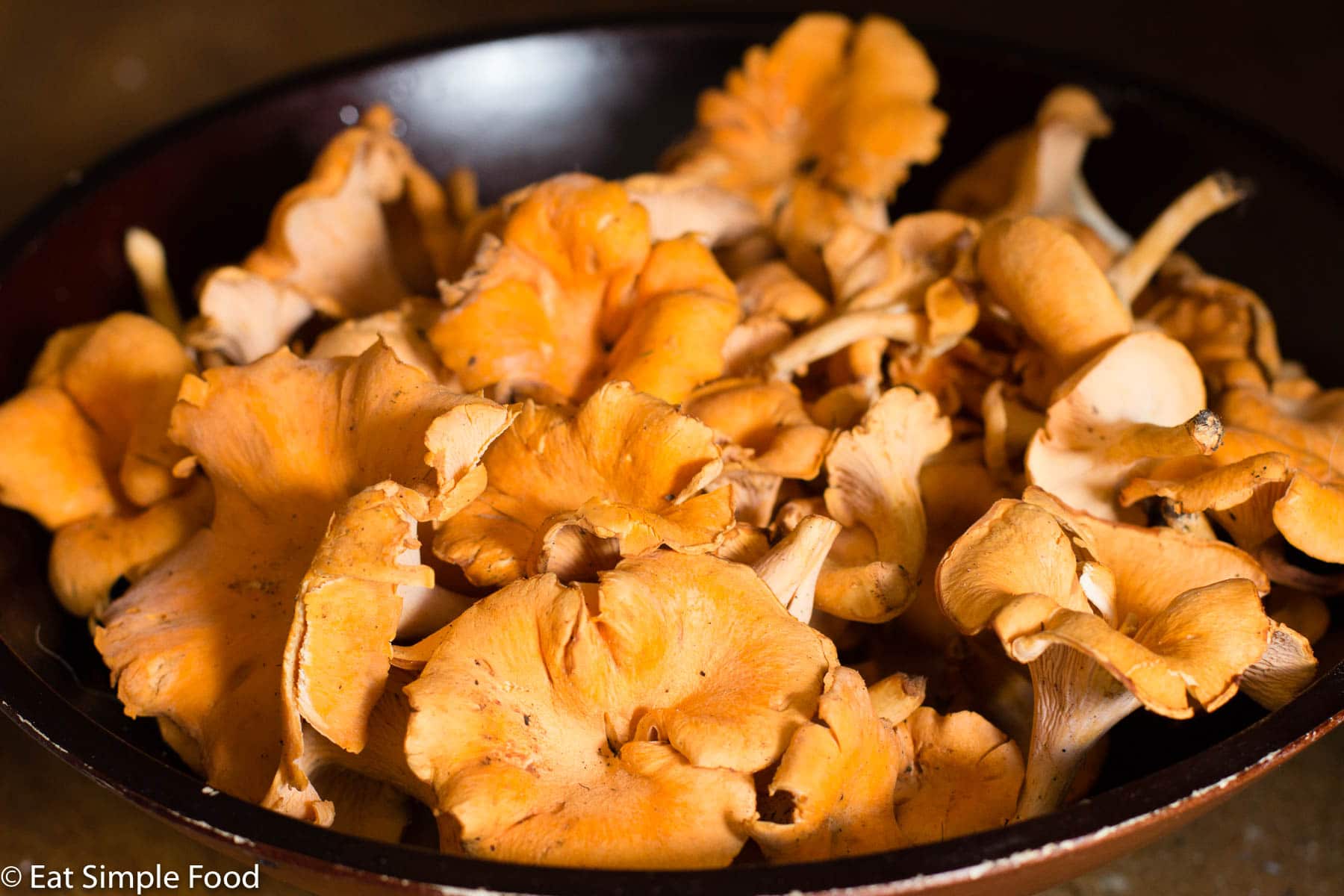 Raw Orange Chanterelle Mushrooms In A Brown Bowl. close up