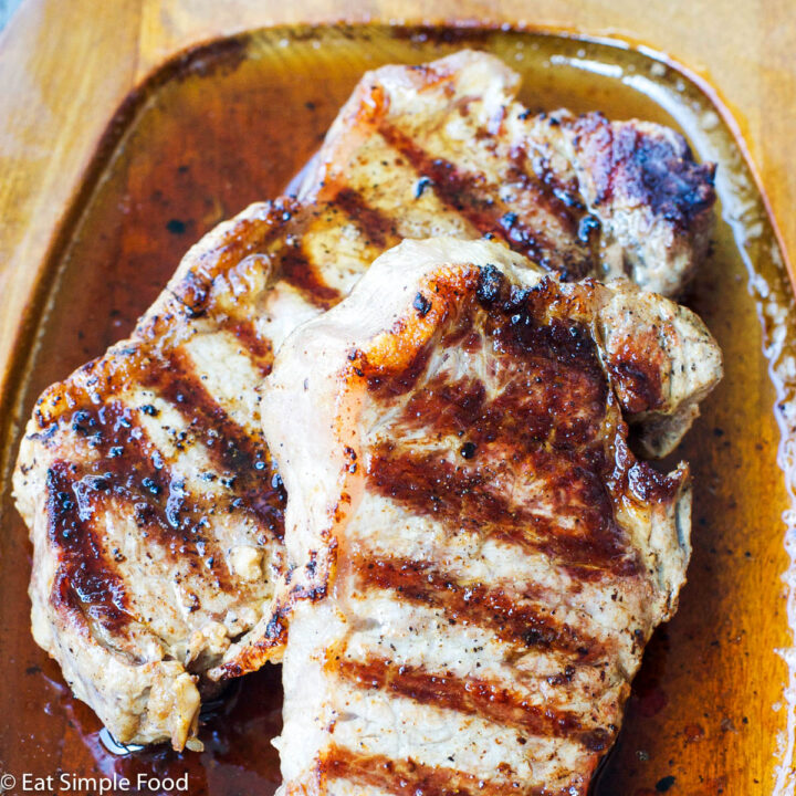 Grilled Steak (New York Strip) on a wooden platter resting in it's juice