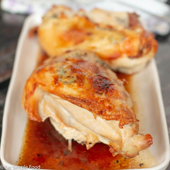 Whole Roasted Turkey Breast in Gravy On White Platter