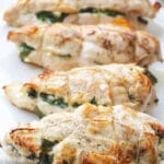 4 Chicken Breasts Stuffed With Feta and Spinach On A White Plate. vertical view.