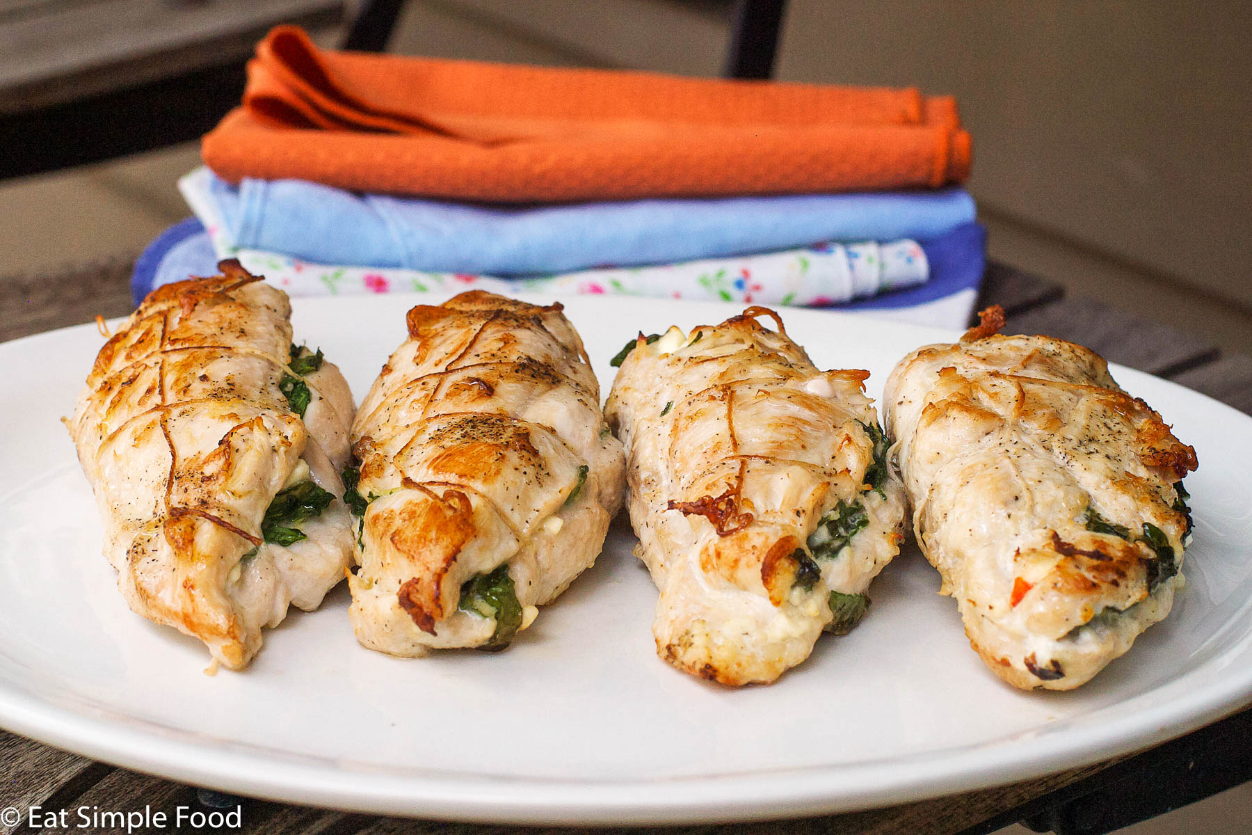 4 Chicken Breasts Stuffed With Feta and Spinach On A White Plate. Horizontal view.