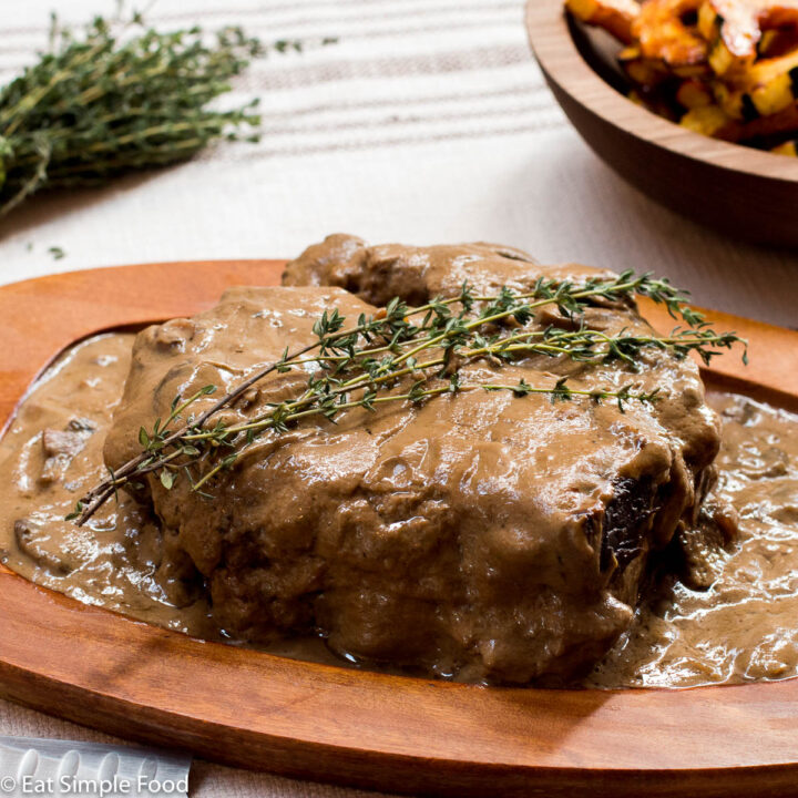 Mushroom Gravy Beef Pot Roast Whole On Wood Serving Platter with Thyme sprig garnish