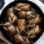 8 Quail Nestled Into And Cooked In A Cast Iron Skillet
