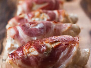 Chicken cutlets are pounded thin in this recipe with a meat mallet, filled with cooked spinach, onions, and garlic, & wrapped in pancetta and held together by toothpicks.