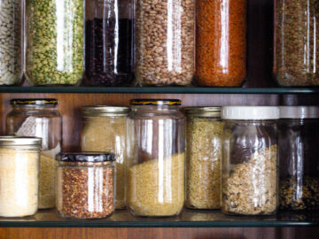3 shelfs of colorful grains in quart size mason jars on stacked wood shelves