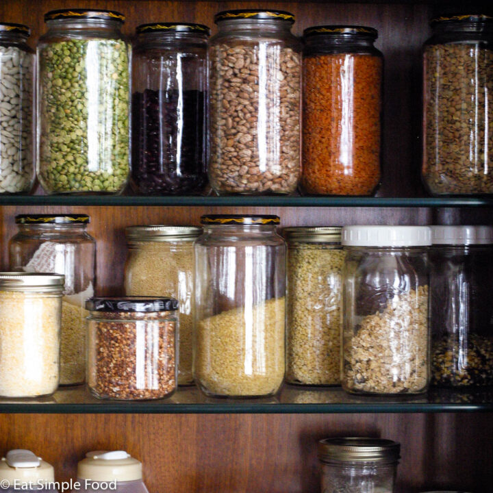 3 shelfs of colorful grains in quart size mason jars on stacked wood shelves