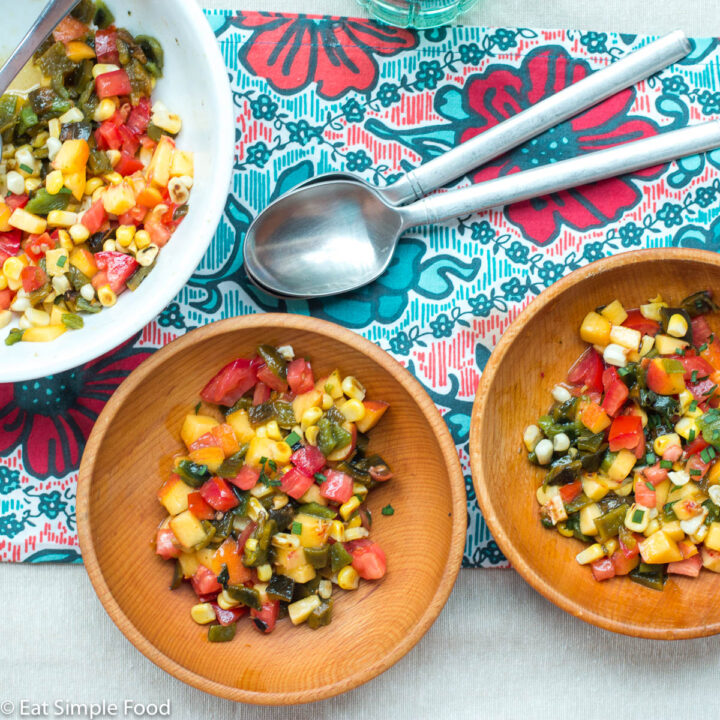 2 wood bowls and one larger white bowl of chunks of peaches, tomato, and corn salsa. Spoons on the side.