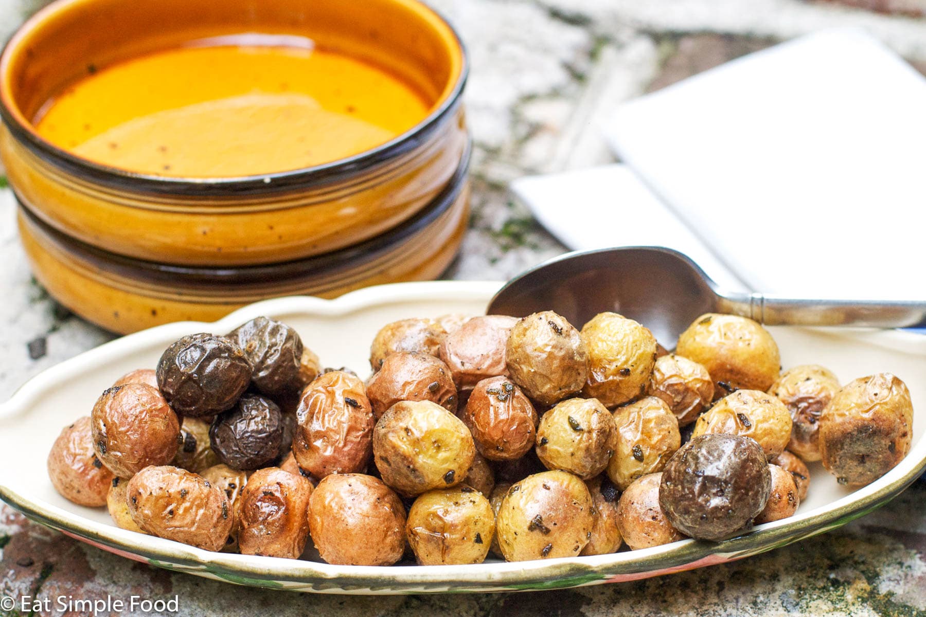 Roasted Whole Baby Potatoes With Rosemary in Shallow White Serving Bowl