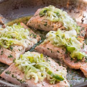 Roast Salmon with Buttery Leeks On Top In a Stainless Steel Pan - Eat Simple Food