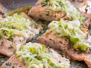 Roast Salmon with Buttery Leeks On Top In a Stainless Steel Pan - Eat Simple Food