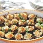Sausage & Cheese Stuffed Mushrooms in Yellow & White Baking Pan with a parsley garnish.