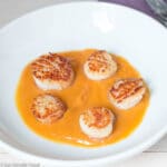 5 Seared Scallops In A Bowl With a Light Layer Of Roasted Sweet Potato Puree