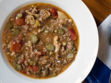 Chicken & Sausage Gumbo in a white shallow bowl with sliced okra.