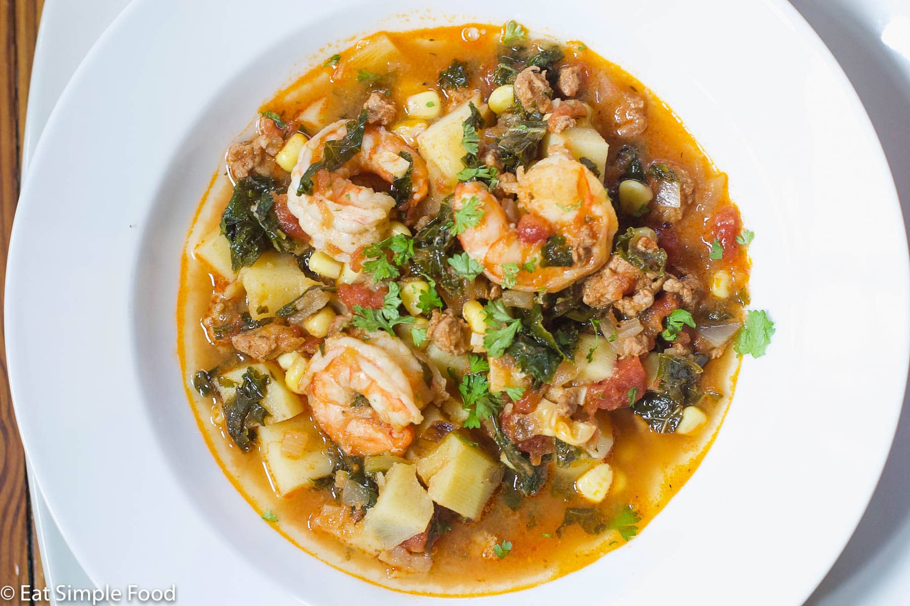 Shrimp and Chorizo Stew w Potatoes and Corn Recipe in A White Bowl. Top View.