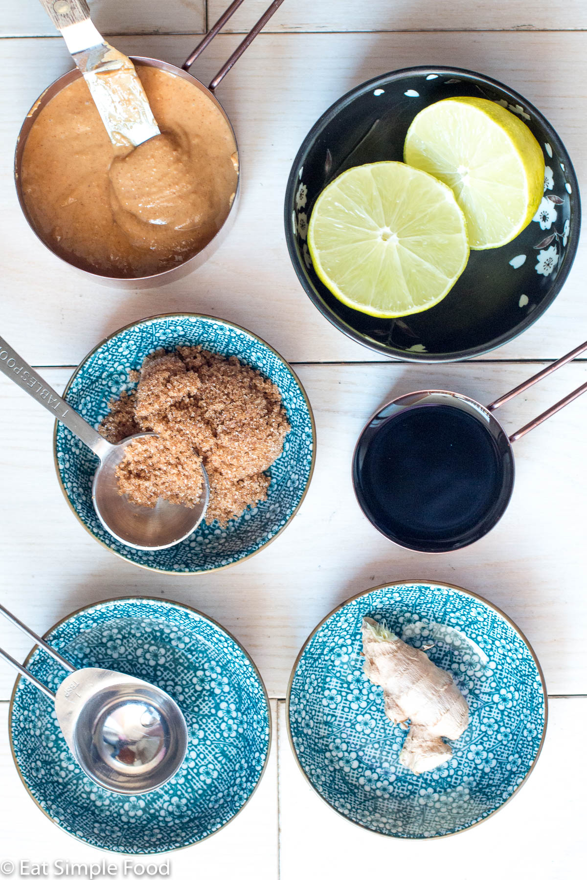 Ingredients for Peanut sauce in small containers: peanut butter, 2 lime halves, brown sugar, soy sauce, water, and a piece of fresh ginger.