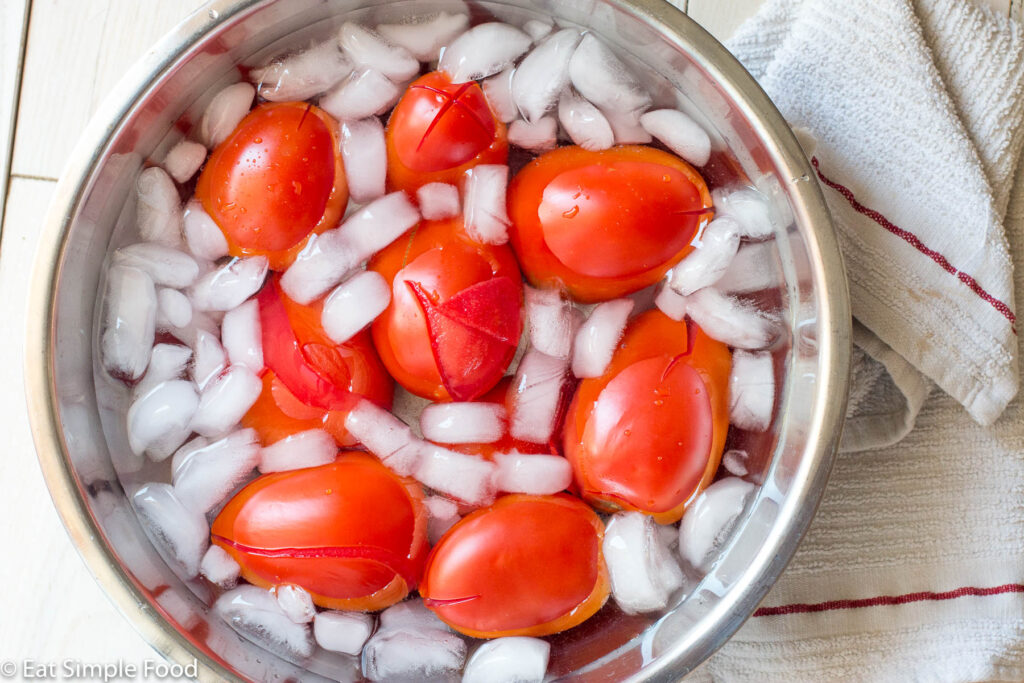 Roma tomatoes cooling in an ice bath to peel the skin away. Top down view.