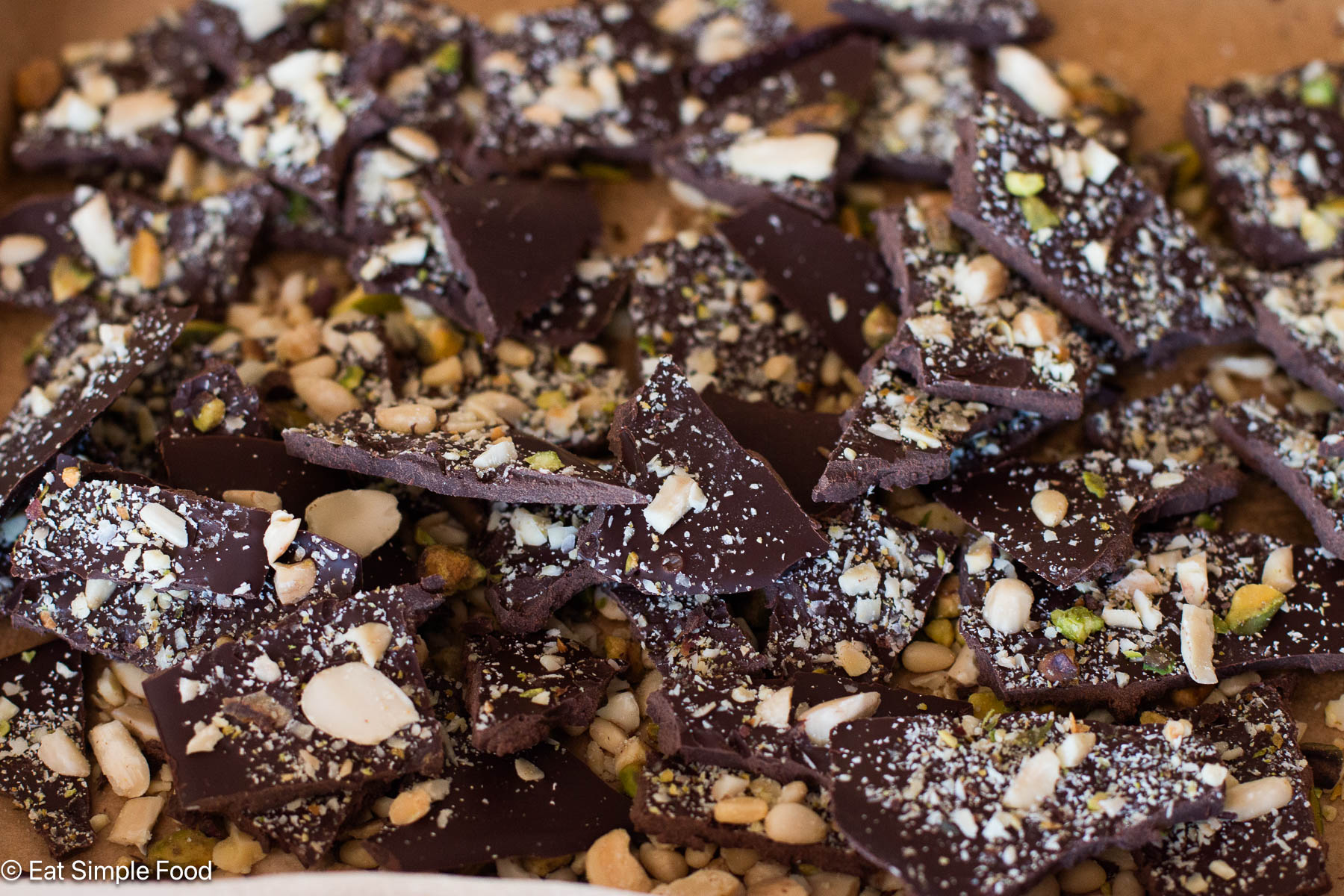 Side view of broken up chocolate pieces with nuts.