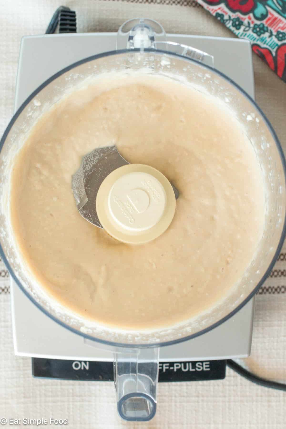 Top down view of creamy white puree in a food processor.