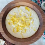 Top down view of white bean dip with lemon zest on top in a wood bowl.