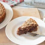 Slice of torte on a white plate with a fork. Napkin on the side.